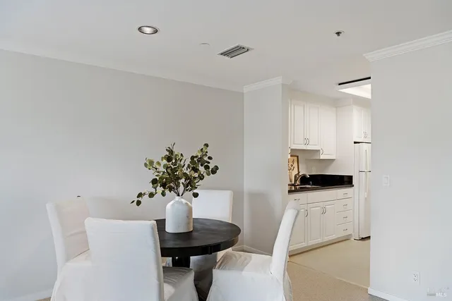 a kitchen with stainless steel appliances kitchen island granite countertop a sink a stove a dining table and chairs