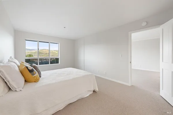 a bed sitting in a bedroom next to a window