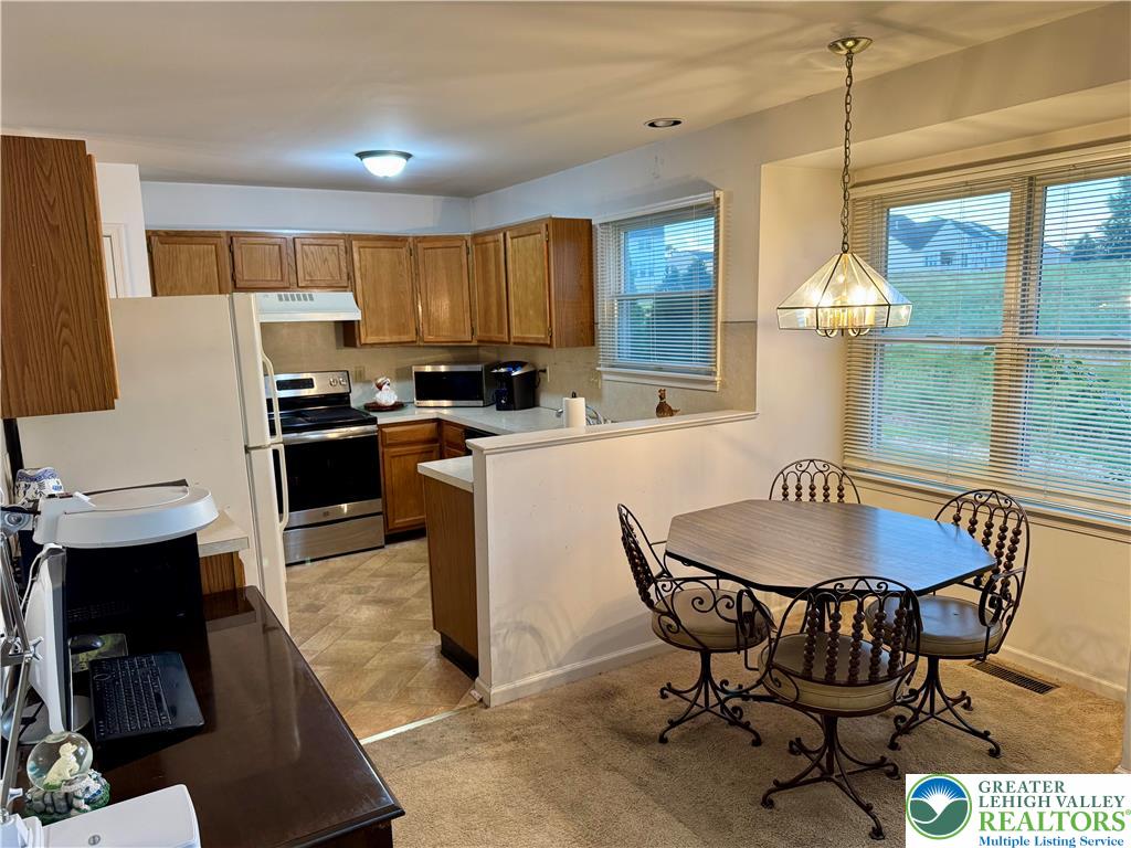 255 Ridings Circle Macungie, PA 18062 - Photo 11 of 30 a kitchen with a dining table chairs and white appliances