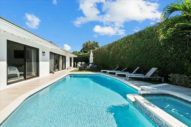 a view of a house with swimming pool and sitting area