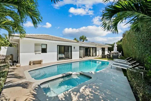 a view of a house with pool and chairs