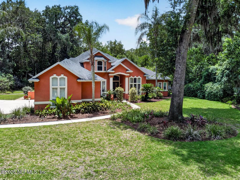 1483 Bridgette Way Fleming Island, FL 32003 - Photo 2 of 63 a front view of a house with a yard and potted plants