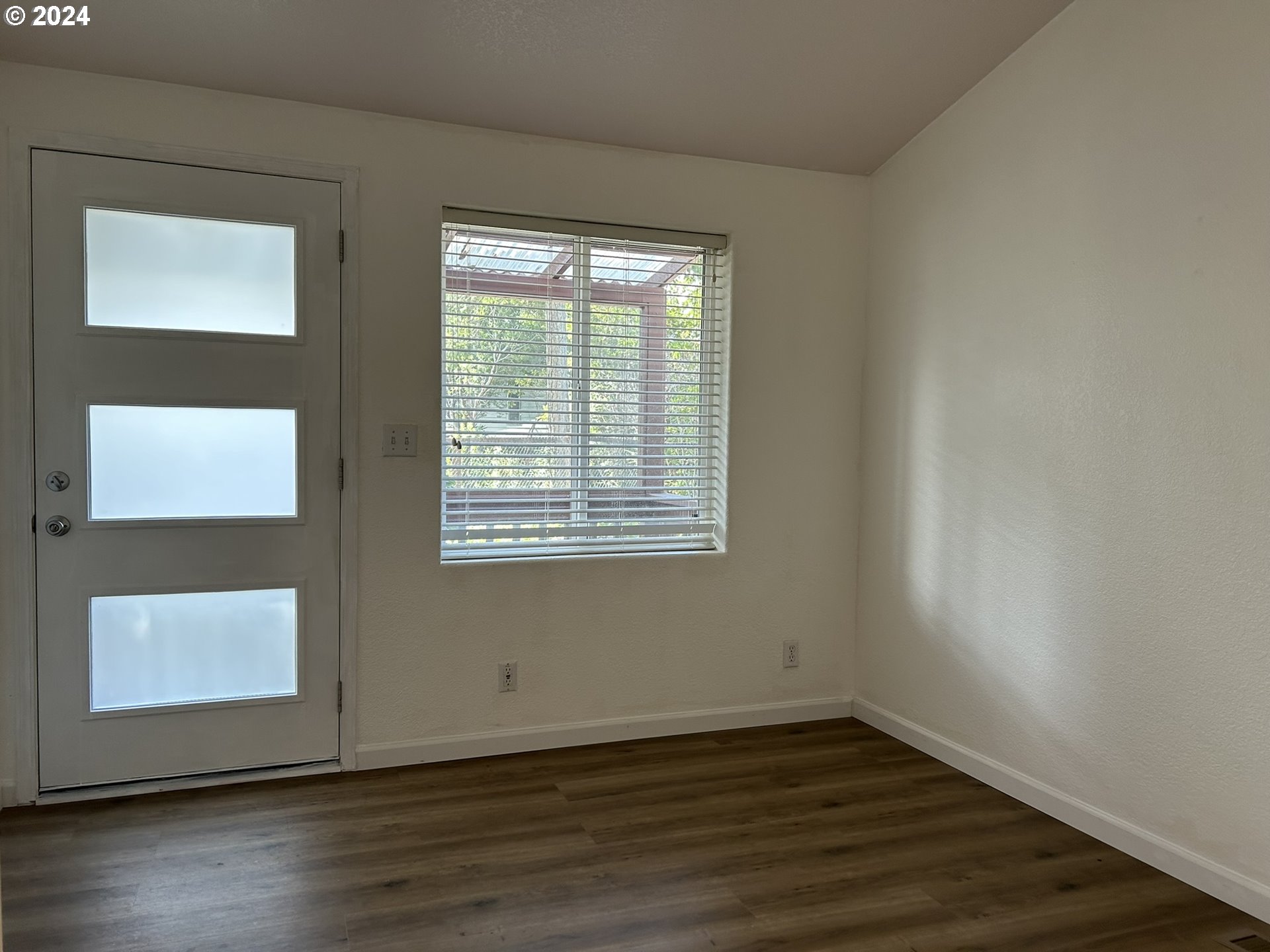 853 Munsel Creek Loop Florence, OR 97439 - Photo 16 of 44 a view of an empty room with wooden floor and a window