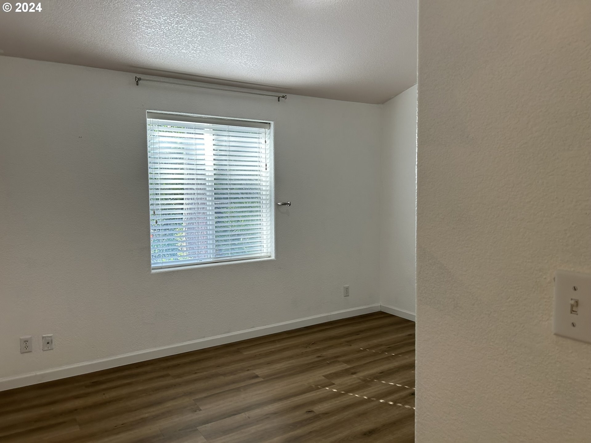 853 Munsel Creek Loop Florence, OR 97439 - Photo 17 of 44 an empty room with wooden floor and windows
