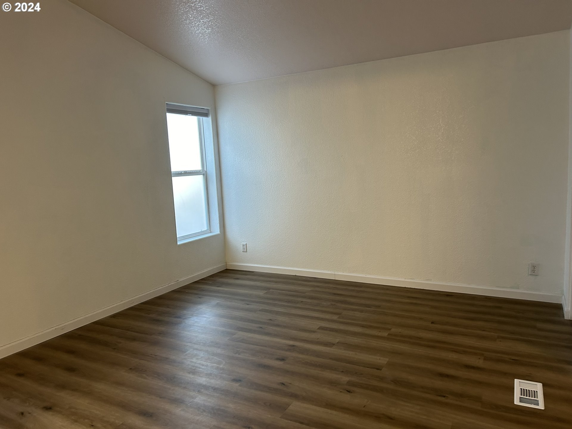 853 Munsel Creek Loop Florence, OR 97439 - Photo 24 of 44 a view of an empty room with wooden floor and a window