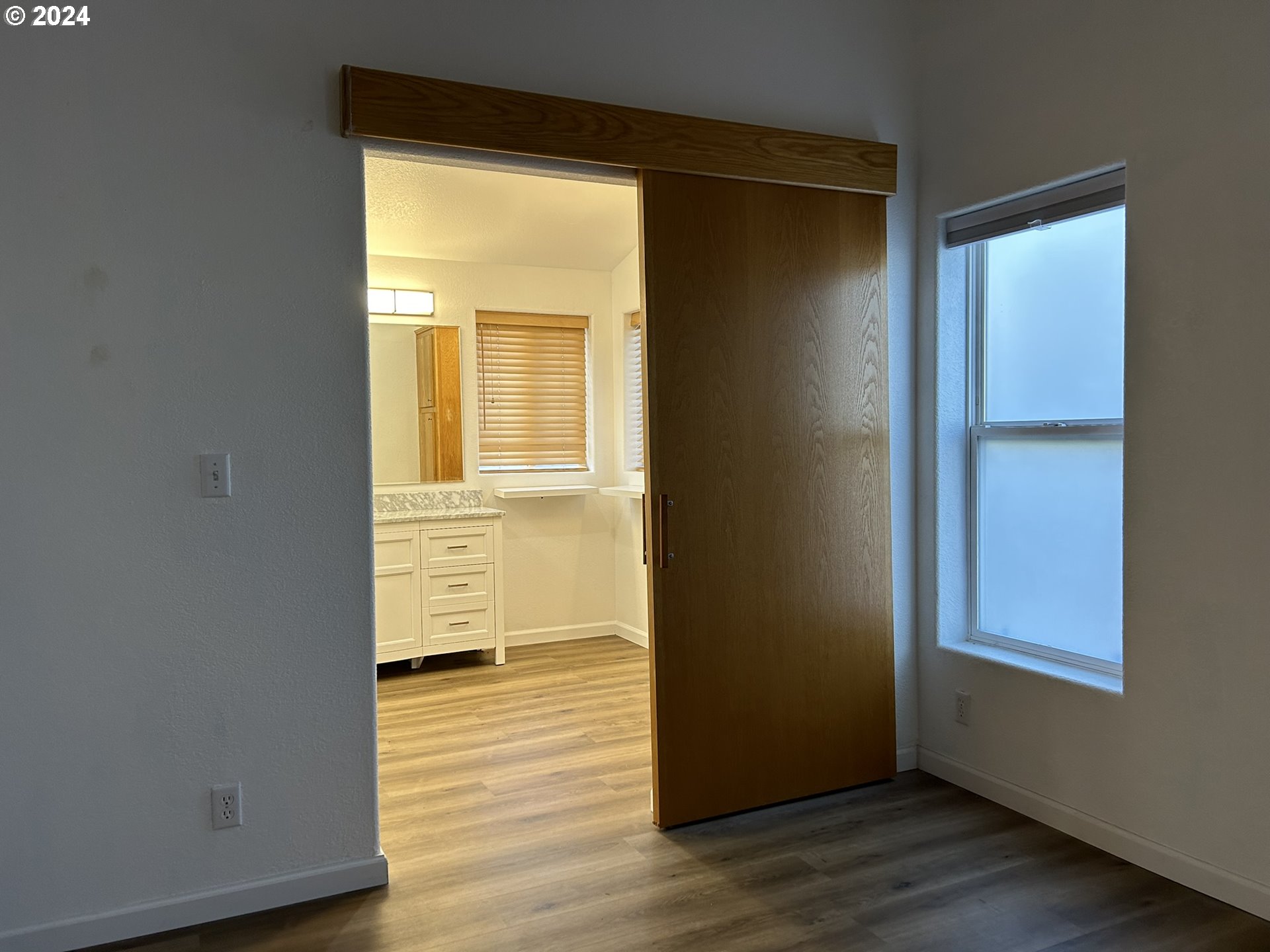 853 Munsel Creek Loop Florence, OR 97439 - Photo 26 of 44 an empty room with wooden floor and windows