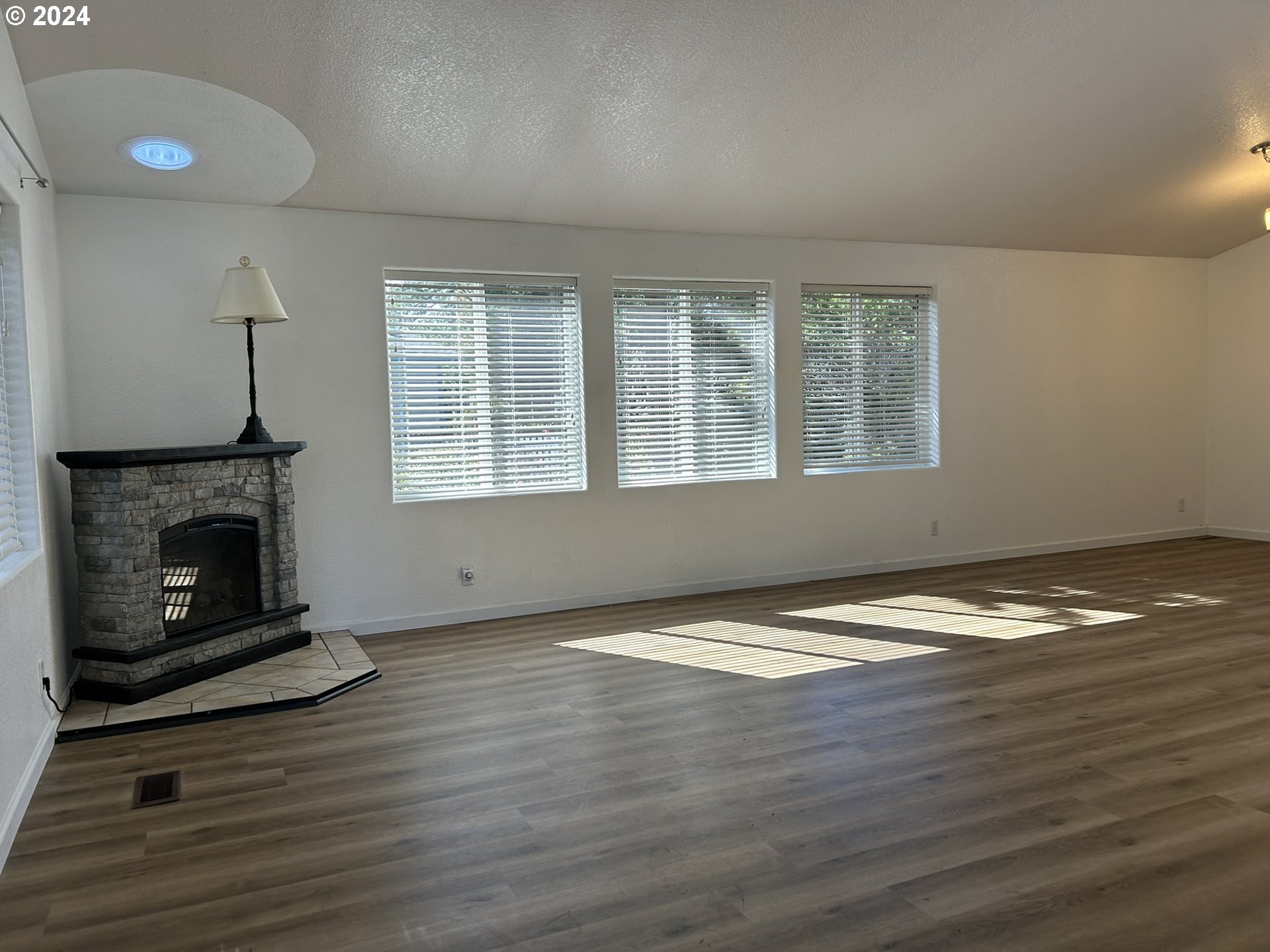 853 Munsel Creek Loop Florence, OR 97439 - Photo 7 of 44 a view of an empty room with wooden floor fireplace and a window