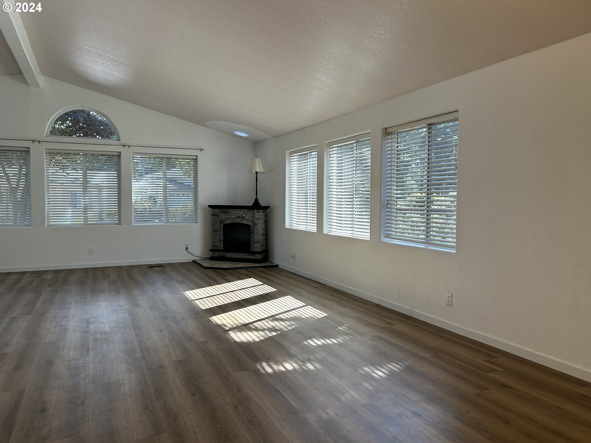 853 Munsel Creek Loop Florence, OR 97439 - Photo 8 of 44 a view of an empty room with wooden floor windows and a fireplace