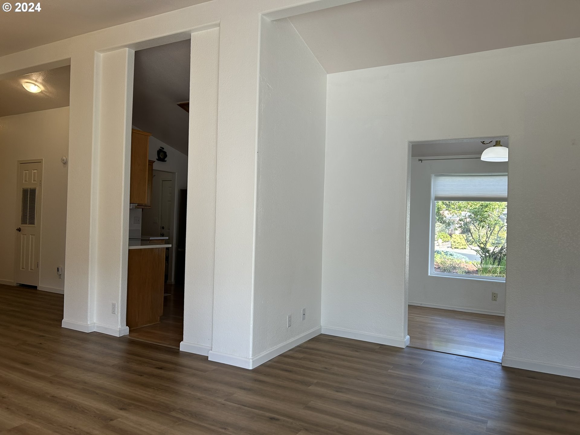 853 Munsel Creek Loop Florence, OR 97439 - Photo 9 of 44 a view of an empty room with wooden floor and a window