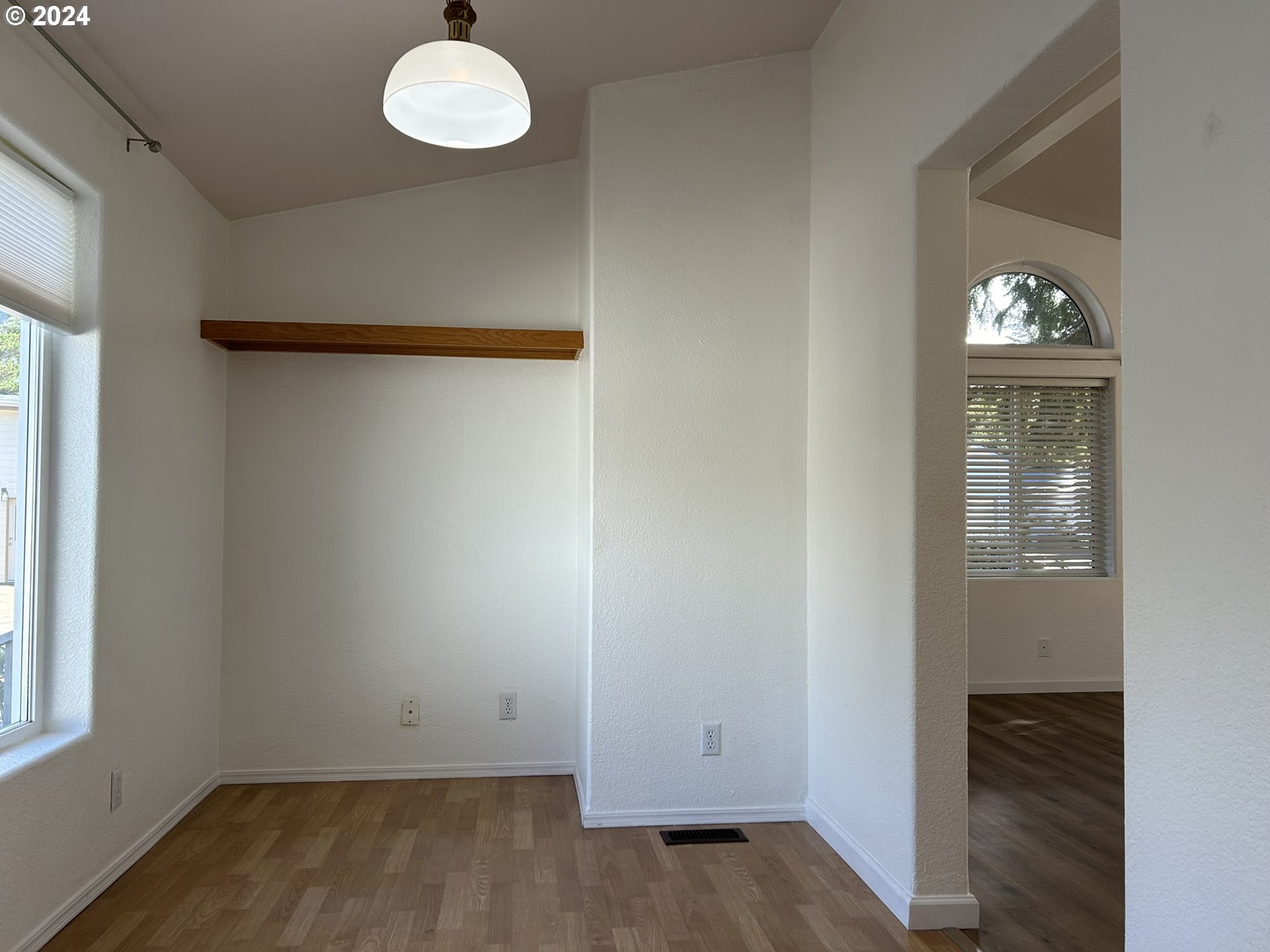 853 Munsel Creek Loop Florence, OR 97439 - Photo 10 of 44 an empty room with wooden floor and windows