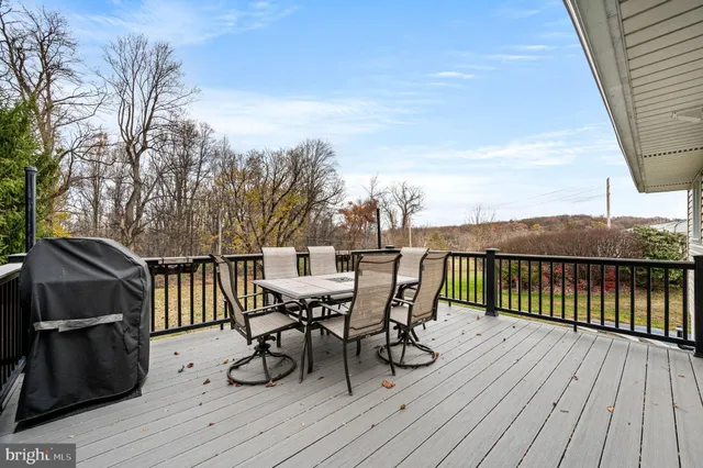 a roof deck with table and chairs and wooden floor