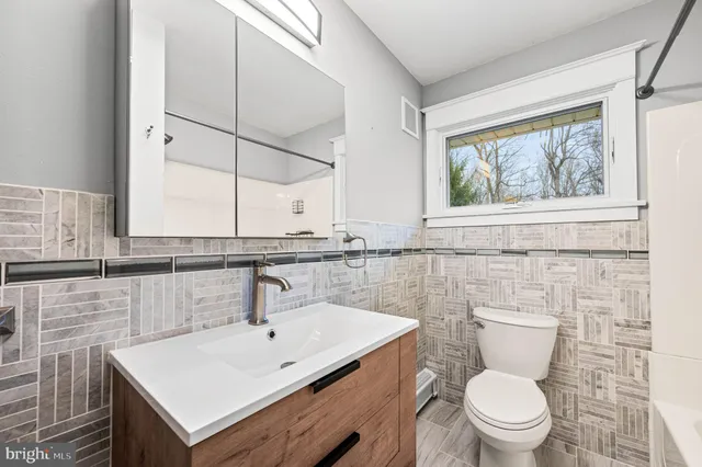 a bathroom with a sink a toilet and a window