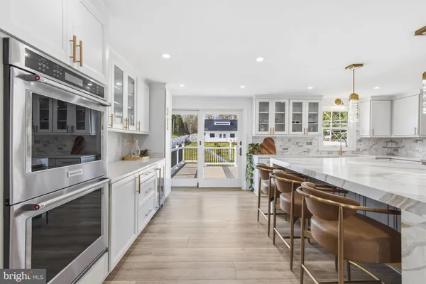 a large kitchen with stainless steel appliances granite countertop a stove and a sink