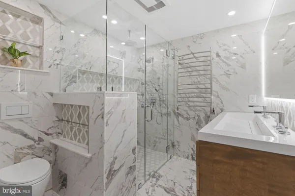 a bathroom with a sink a toilet and shower