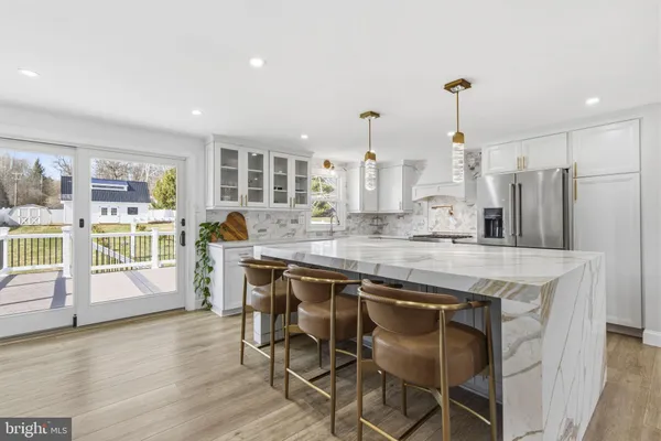 a kitchen with stainless steel appliances granite countertop wooden floor window and cabinets