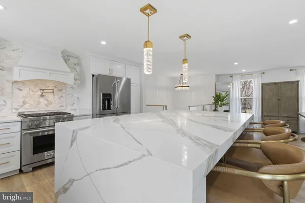 a large white kitchen with a stove a sink and a fireplace