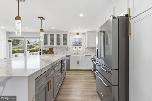 a kitchen with stainless steel appliances granite countertop a sink a stove and a refrigerator