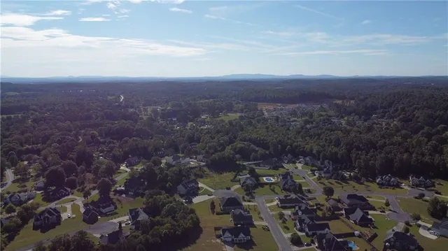 an aerial view of a city with lots of residential buildings lake and mountain view in back