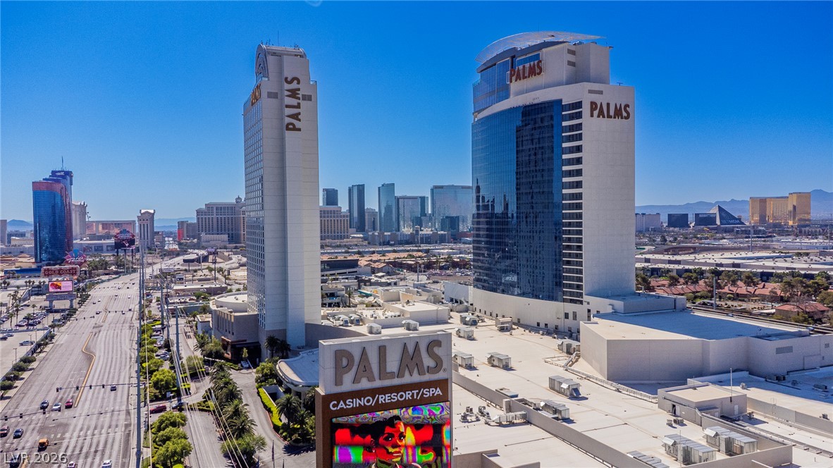 4381 West Flamingo Road, Unit 3002 Las Vegas, NV 89103 - Photo 38 of 59 Towering high-rises overlook the city skyline and mountains under a clear blue sky.