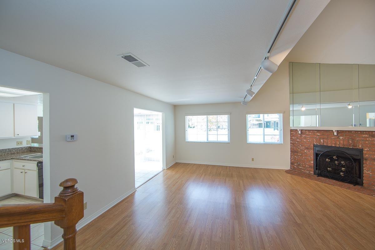 1854 Rory Lane, Unit 3 Simi Valley, CA 93063 - Photo 15 of 29 an empty room with windows a fireplace and wooden floor