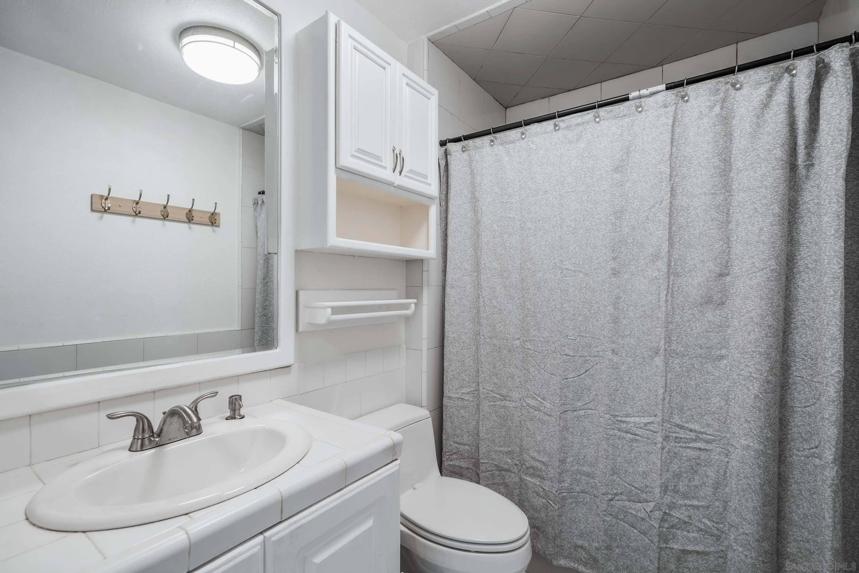6275 Rancho Mission Road, Unit 105 San Diego, CA 92108 - Photo 18 of 24 a bathroom with a sink toilet and shower