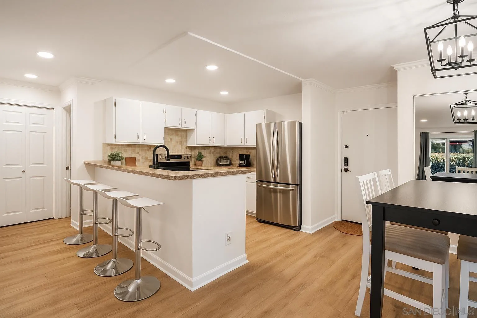 6275 Rancho Mission Road, Unit 105 San Diego, CA 92108 - Photo 2 of 24 a kitchen with kitchen island a refrigerator a stove a sink and a counter