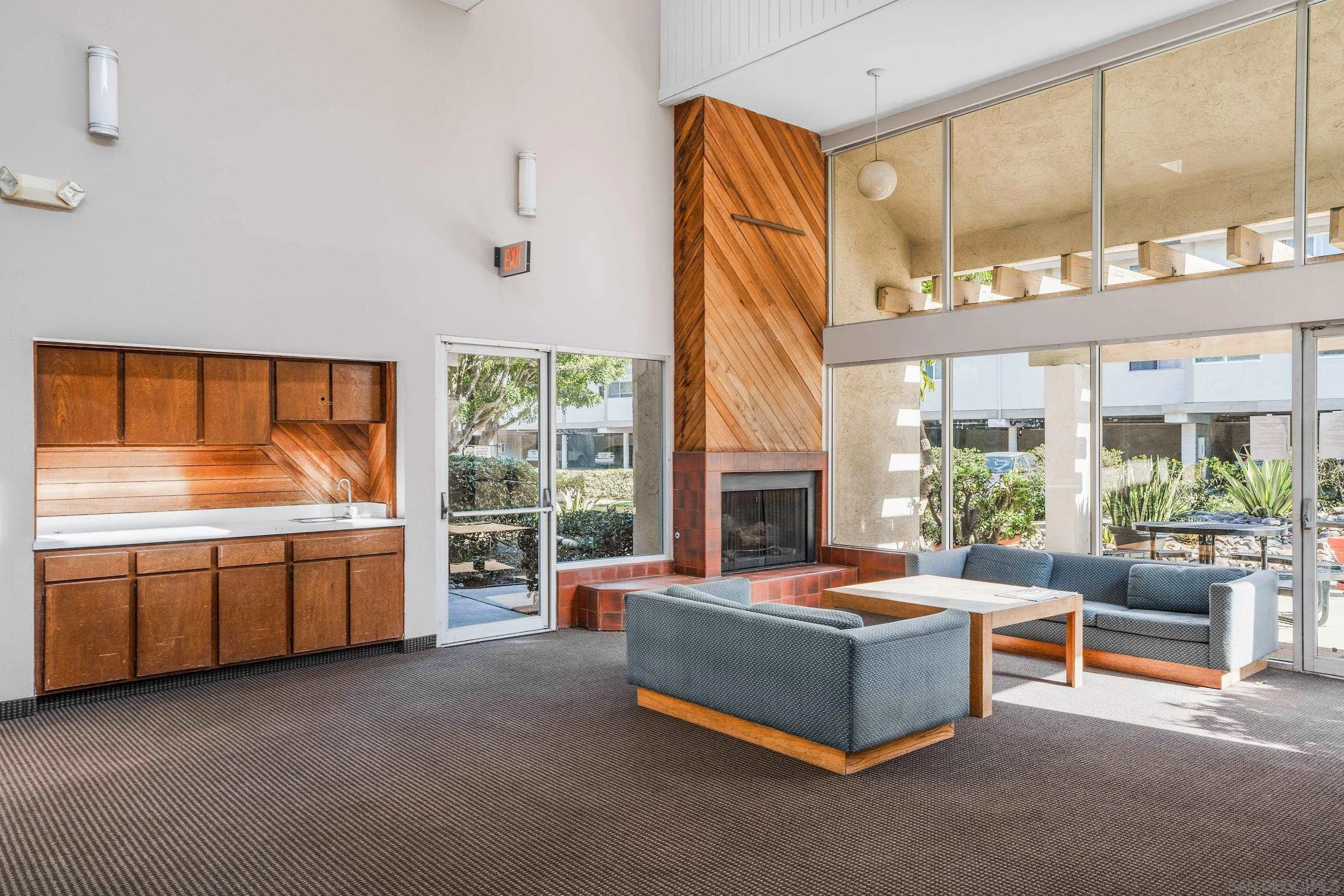 6275 Rancho Mission Road, Unit 105 San Diego, CA 92108 - Photo 21 of 24 a living room with furniture a fireplace and windows