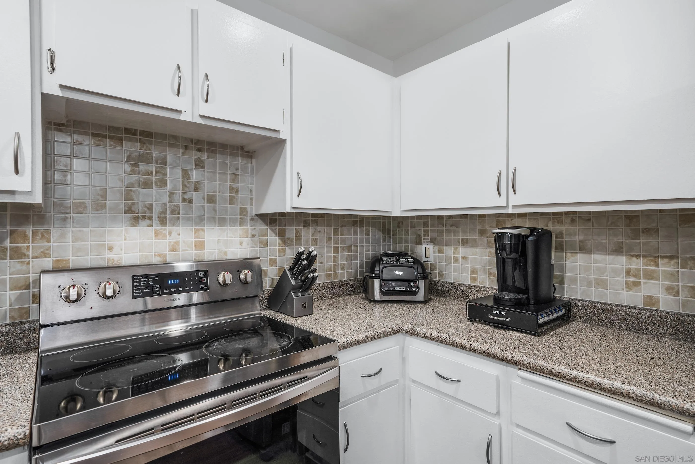 6275 Rancho Mission Road, Unit 105 San Diego, CA 92108 - Photo 6 of 24 a kitchen with a stove and cabinets