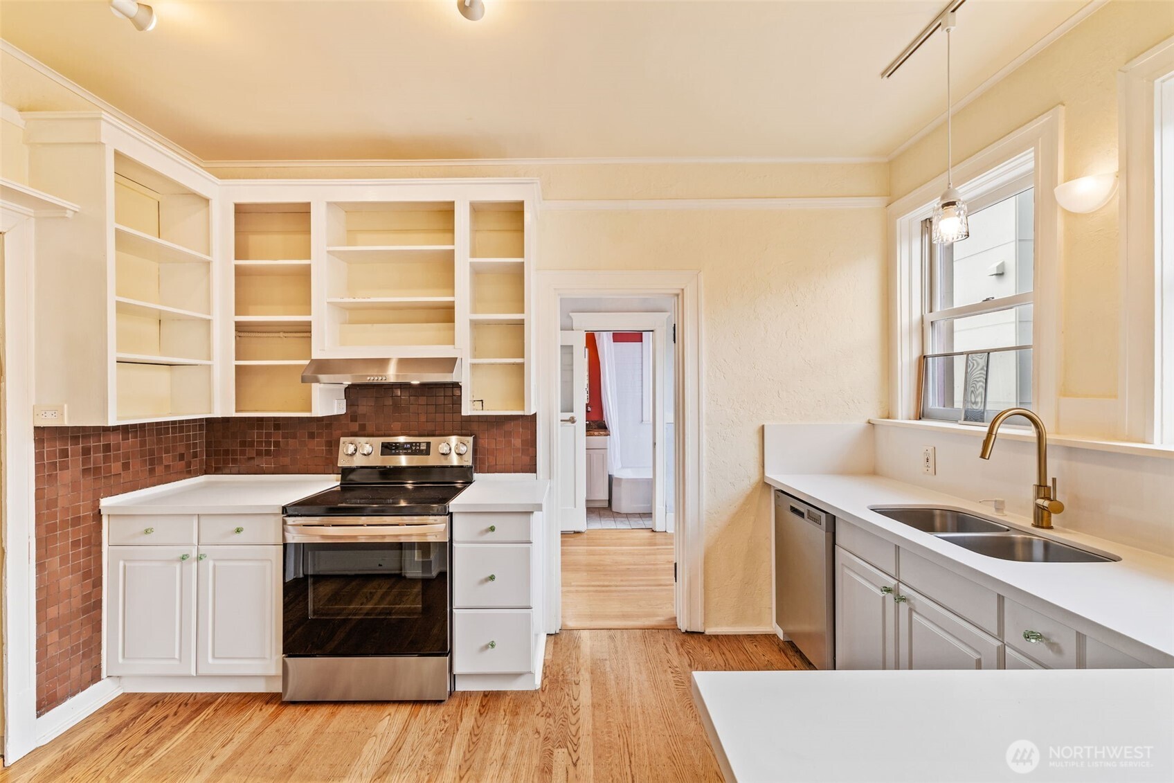 2915 Franklin Avenue East, Unit A Seattle, WA 98102 - Photo 12 of 34 a kitchen with stainless steel appliances a stove a sink and a microwave