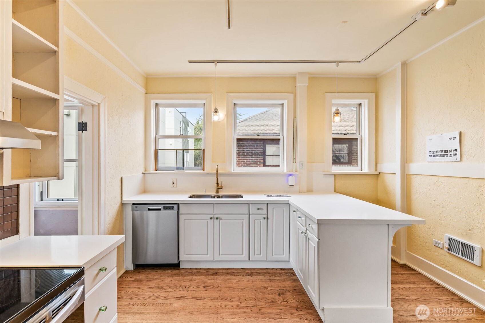2915 Franklin Avenue East, Unit A Seattle, WA 98102 - Photo 13 of 34 a large white kitchen with cabinets and wooden floor