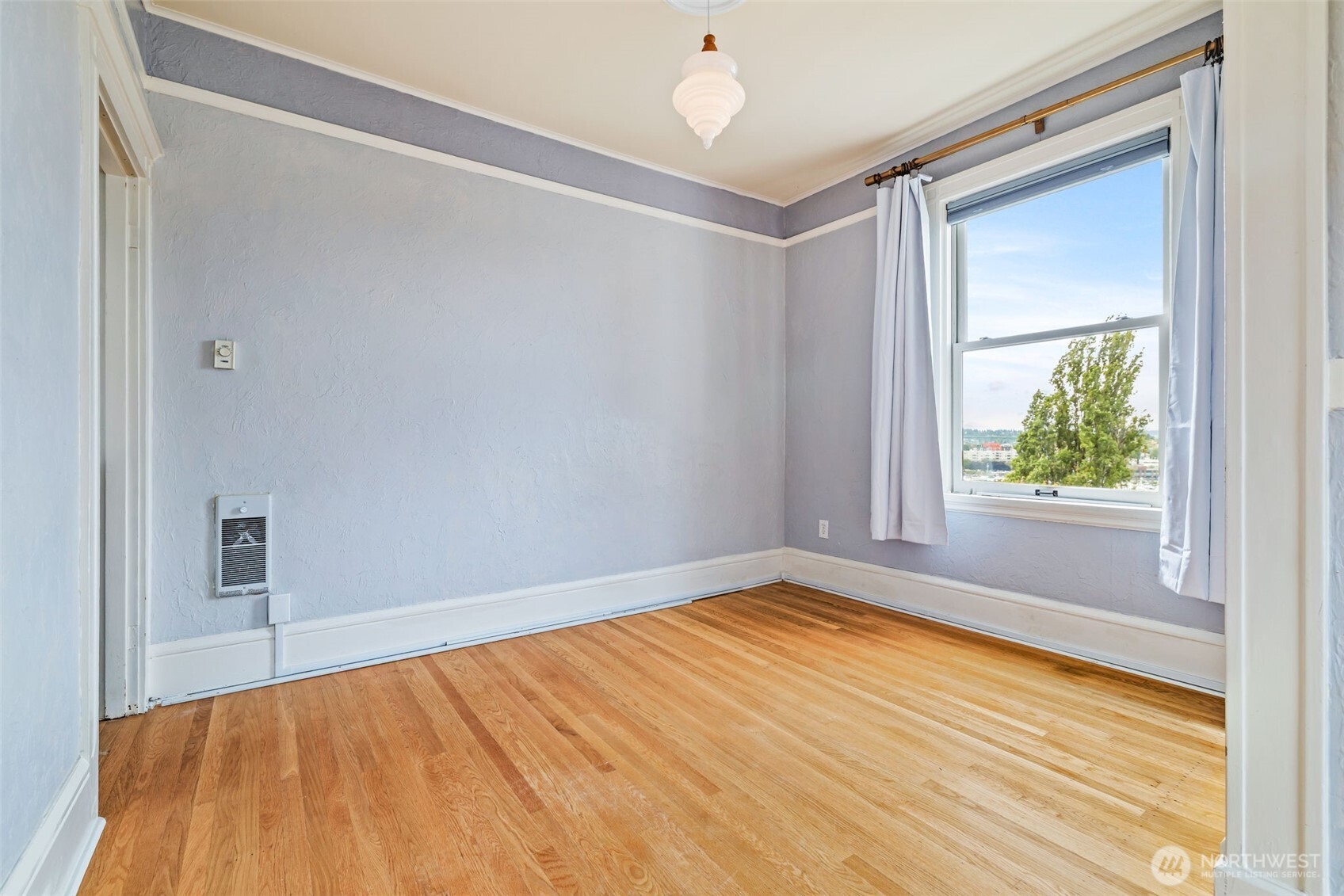 2915 Franklin Avenue East, Unit A Seattle, WA 98102 - Photo 15 of 34 a view of an empty room with a window and wooden floor