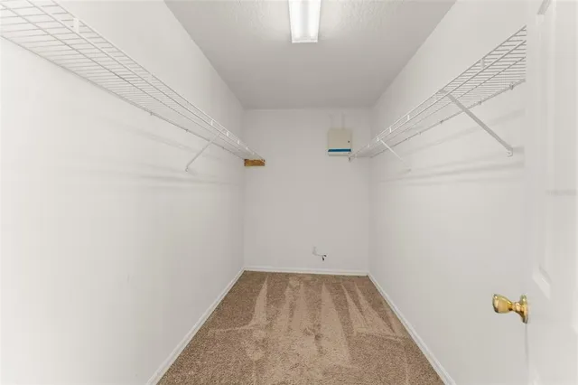 a view of an empty room with a window and fireplace