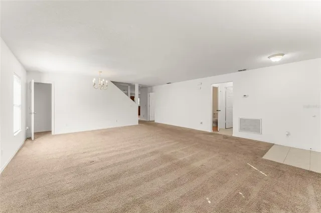 an empty room with a chandelier fan