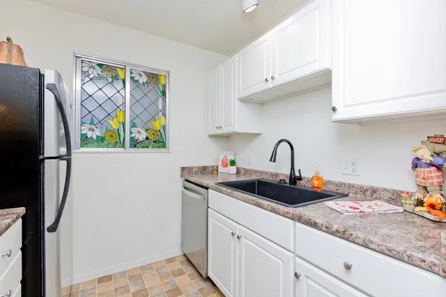 a kitchen with stainless steel appliances granite countertop a sink and a refrigerator