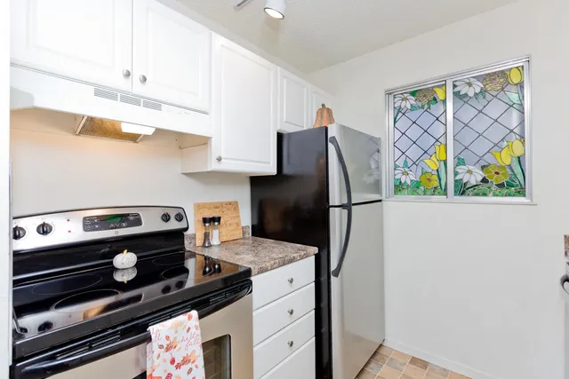a kitchen with a refrigerator and a stove top oven