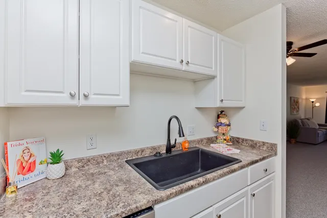 a kitchen with white cabinets a sink and dishwasher