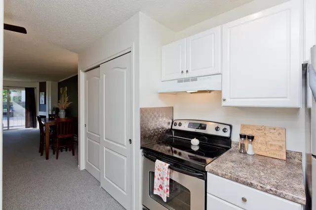 a kitchen with granite countertop a sink stove and cabinets