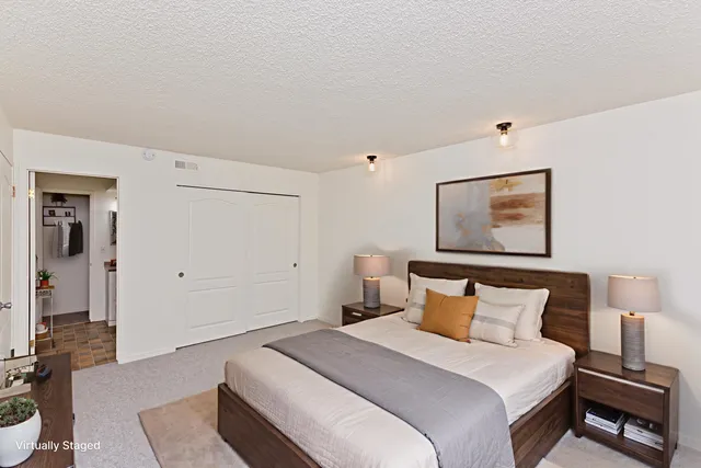 a bedroom with a bed and a painting on the wall