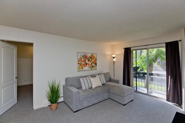 a spacious bedroom with a large window and a couch
