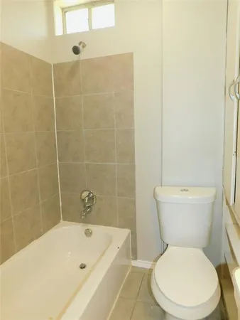 a white toilet sitting next to a bath tub