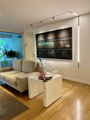 a living room with furniture wooden floor and a large window