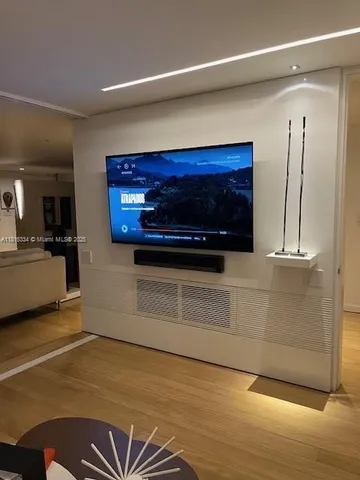 a room with kitchen island stainless steel appliances and wooden floor