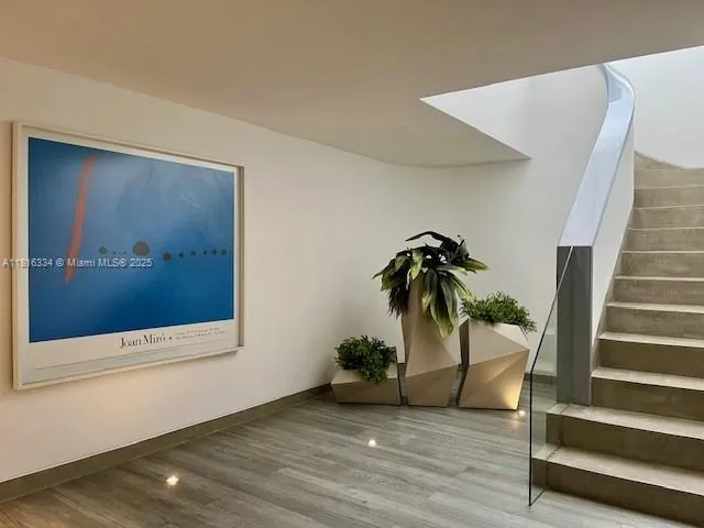 a view of a hallway with wooden floor and stairs