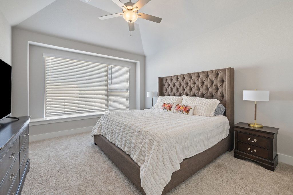 1113 Spring Gulch Lane Georgetown, TX 78628 - Photo 13 of 19 a bedroom with a bed and a flat tv screen on a dresser