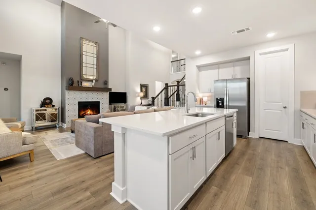 a view of living room kitchen with stainless steel appliances granite countertop furniture and fireplace