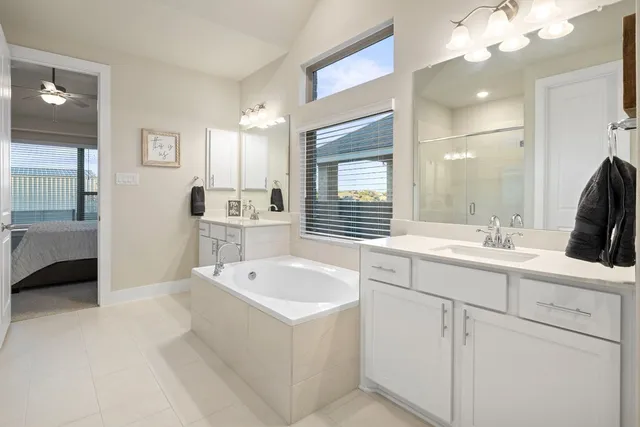 a spacious bathroom with a sink a large mirror and a bathtub