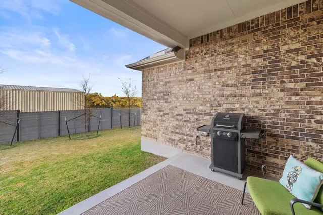 a view of a backyard with couches plants and wooden fence
