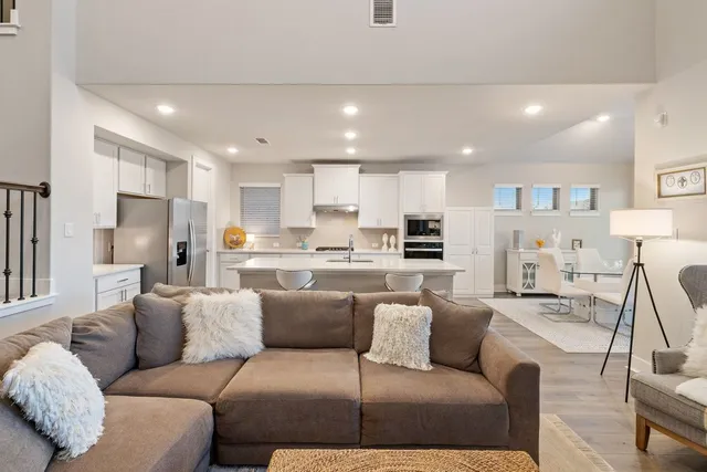 a view of kitchen with kitchen island stainless steel appliances refrigerator stove dining table and chairs