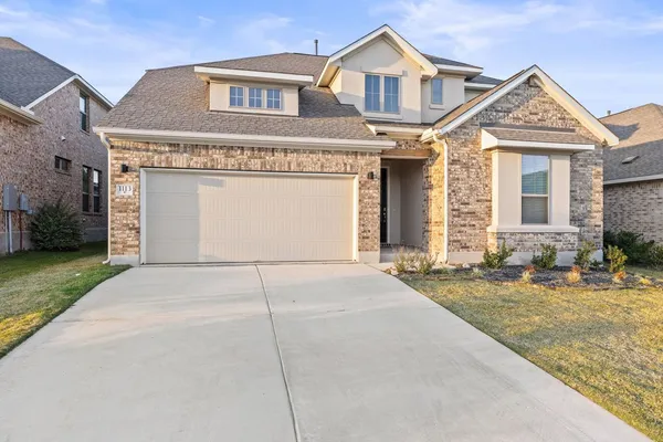 a front view of a house with a yard and garage