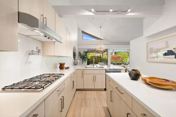 a view of kitchen with stainless steel appliances wooden floor and refrigerator